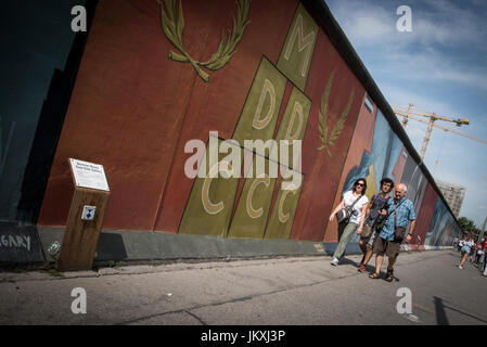 Berlin, Deutschland. 20. Juli 2017. Besucher zu Fuß entlang der East Side Gallery, ein Meile-langes Teilstück der Berliner Mauer noch steht, d. h. in Wandmalereien und Graffiti, am 20. Juli 2017, in Berlin, Deutschland abgedeckt. Die Arbeit von 118 Künstlern aus 21 Ländern ist auf dem Display, Sehenswürdigkeiten aus dem kalten Krieg, als die Stadt, zwischen Ost geteilt war und West, sind jetzt große Touristenattraktionen. Bildnachweis: Andrea Ronchini/Pacific Press/Alamy Live-Nachrichten Stockfoto