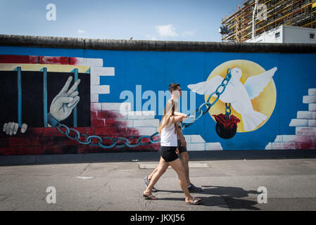 Berlin, Deutschland. 20. Juli 2017. Besucher zu Fuß entlang der East Side Gallery, ein Meile-langes Teilstück der Berliner Mauer noch steht, d. h. in Wandmalereien und Graffiti, am 20. Juli 2017, in Berlin, Deutschland abgedeckt. Die Arbeit von 118 Künstlern aus 21 Ländern ist auf dem Display, Sehenswürdigkeiten aus dem kalten Krieg, als die Stadt, zwischen Ost geteilt war und West, sind jetzt große Touristenattraktionen. Bildnachweis: Andrea Ronchini/Pacific Press/Alamy Live-Nachrichten Stockfoto