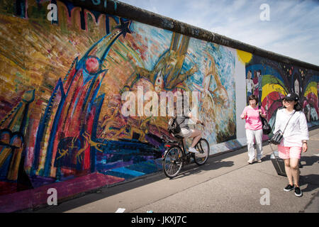 Berlin, Deutschland. 20. Juli 2017. Besucher zu Fuß, entlang der East Side Gallery, ein Meile-langes Teilstück der Berliner Mauer steht noch, die Wandmalereien und Graffiti bedeckt ist. Die Arbeit von 118 Künstlern aus 21 Ländern ist auf dem Display, Sehenswürdigkeiten aus dem kalten Krieg, als die Stadt, zwischen Ost geteilt war und West, sind jetzt große Touristenattraktionen. Bildnachweis: Andrea Ronchini/Pacific Press/Alamy Live-Nachrichten Stockfoto