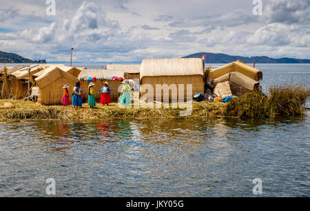 UROS-Inseln, PERU - ca. APRIL 2014: Frauen aus den Uros Inseln im Titicaca-See warten auf Touristen ankommen. Stockfoto