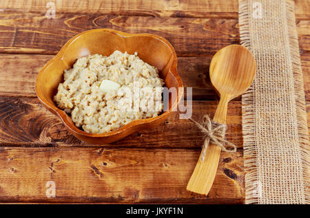 Haferflocken in eine Kupferplatte auf einem Holztisch Hafer Flocke Stockfoto