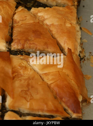 Spanakopita, auch bekannt als Spinatpastete, ein gebackenen herzhaften griechischen Gericht mit Phyllo Gebäck, geschichtet mit Spinat und Feta-Käse auf ein Backblech Stockfoto