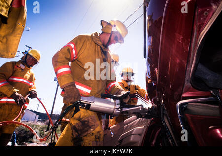 South Dakota Feuerwehrmänner nehmen an Opfer extrication Ausbildung bei Kraftfahrzeugen mit einer hydraulischen Neugierigen und Schneidwerkzeuge crash Szenario. Stockfoto