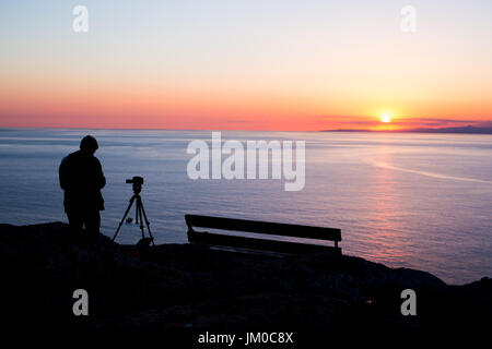 Mann-Fotografen Fotografieren von Sonnenuntergang am Meer. Stockfoto