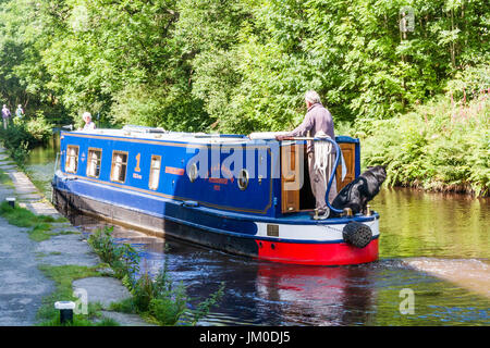 Älteres Ehepaar etwa, deren Narrowboat über Huddersfield schmaler Kanal Marsden, West Yorkshire, England moor Stockfoto
