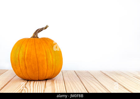 Ein dekorativer Kürbis (Jack O´Lantern) liegt auf Holz mit Hintergrund für einen text Stockfoto