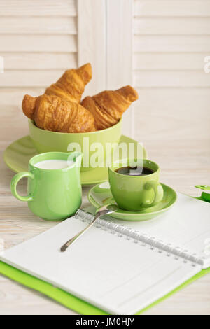 Kaffee mit Milch und Croissants und ein Notizblock. Selektiven Fokus. Stockfoto