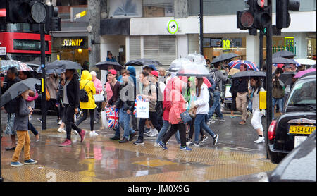 PIX zeigt: nasse Sommer in London. Regen geschlagene Shopper in der Oxford Street in der Nähe von John Lewis Shop.     Bild von Gavin Rodgers/Pixel 8000 Ltd Stockfoto