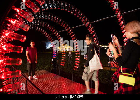 BONTIDA, Rumänien - 13. Juli 2017: Leere Coca Cola-Flaschen sind in Form eines Tunnels angeordnet und beleuchtet mit roten Lichtern an elektrischen Burg festi Stockfoto