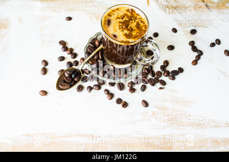 Tasse Kaffee und Kaffeebohnen auf rustikalen Tisch. Ansicht von oben Stockfoto