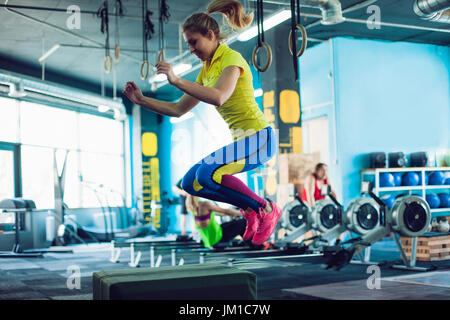 Springen auf Box-Training in der Turnhalle, cross-Fit Fitness-Frau Stockfoto