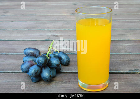 Trauben und Getränk auf der Holzoberfläche. Stockfoto