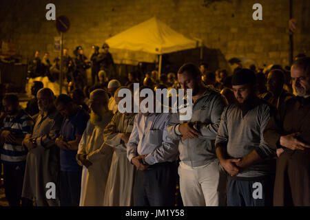 (170725)--JERUSALEM, 25. Juli 2017 (Xinhua)--Menschen beten außerhalb des Löwen Tor der Altstadt von Jerusalem, 25. Juli 2017. Israels Sicherheit Kabinett hat beschlossen, Metalldetektoren vom Eingang auf die heilige Stätte in Jerusalem zu entfernen, die bekannt ist als das edle Heiligtum für Muslime und Tempelberg für Juden und Sicherheit ergreifen basierende auf fortschrittliche Technologien Maßnahmen ("smart Kontrollen") statt, laut Aussage vom Amt des Premierministers am Dienstagmorgen ausgestellt. (Xinhua/Guo Yu) (Zjy) Stockfoto