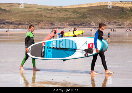 Polzeath, Cornwall, UK. 25. Juli 2017. Surfer und Boarder Paddel nutzen das warme sonnige Wetter auf Polzeath Strand, North Cornwall. Bildnachweis: Mark Richardson/Alamy Live Newspaddle Stockfoto