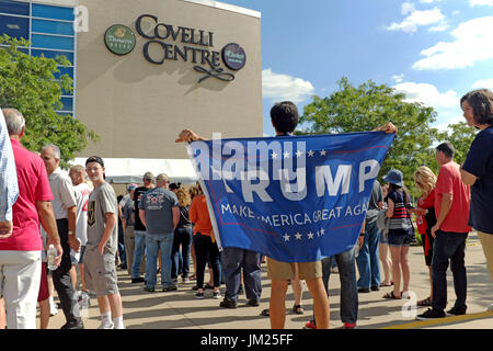 Youngstown, Ohio, USA. 25. Juli 2017. Mann steht mit seinem Trumpf "Machen Amerika große wieder" banner während er wartet mit anderen Unterstützern Trump Covelli Centre in Youngstown, Ohio zu einer politischen Kundgebung am 25. Juli 2017 eingeben. Bildnachweis: Mark Kanning/Alamy Live-Nachrichten Stockfoto