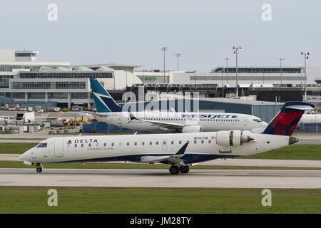 Richmond, British Columbia, Kanada. 9. April 2017. Eine Dreieckschaltung (SkyWest Airlines) Bombardier CRJ-701 Regionalverkehrsflugzeug geht von WestJet Boeing 737 landet auf dem Flughafen Vancouver International Airport. SkyWest Airlines betreibt die Regionaljet unter Vertrag, Delta Air Lines. Bildnachweis: Bayne Stanley/ZUMA Draht/Alamy Live-Nachrichten Stockfoto