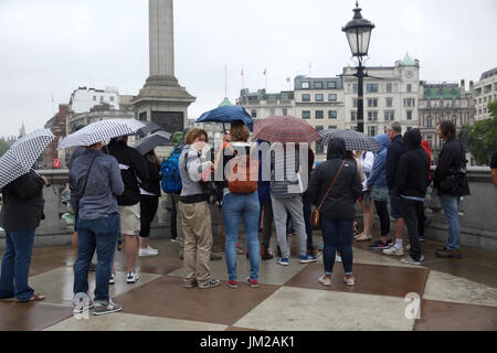 London, UK. 26. Juli 2017. Die typisch britische nasse und düstere Wetter nicht davon abhalten, Besucher und Touristen in Trafalgar Square London Credit: Keith Larby/Alamy Live News Stockfoto