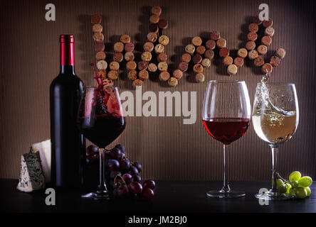 Weinkonzept Flasche und Gläser mit roten, rosa und weißen Spritzer Wein am Tisch mit Wein in Korken geschriebene Wort Stockfoto