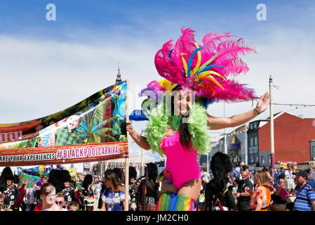 Blackpool internationaler Karneval. Attraktive Mädchen auf Stelzen in bunten Kostüm winkt in die Menge Stockfoto