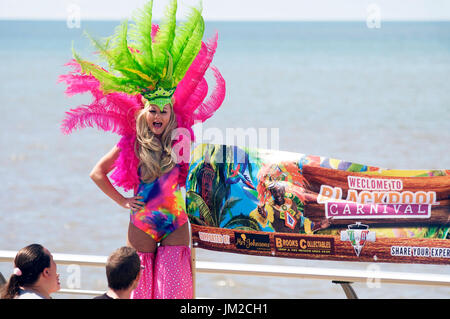 Mädchen auf Stelzen begrüßt Menschen zum Blackpool International Karneval anzeigen