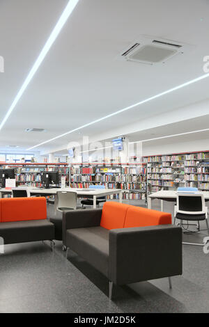 Innenansicht der neu restaurierten Marcus Garvey Bibliothek in London Borough of Haringey, Vereinigtes Königreich. Zeigt traditionelle Bücherregale und neue Computer-Terminals. Stockfoto