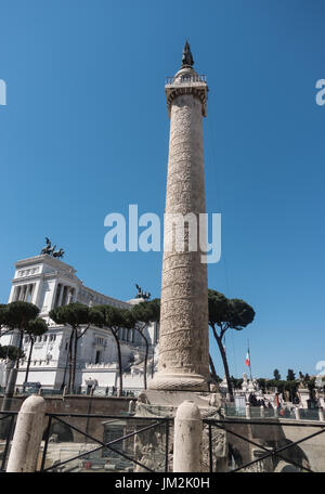 Antike Trajans Säule mit Spirale Flachrelief; Victor Emmanuel II im Hintergrund. St. Peter Bronze Statue Spitze, aufgestellt durch Papst Sixtus 5 im Jahre 1587. Stockfoto