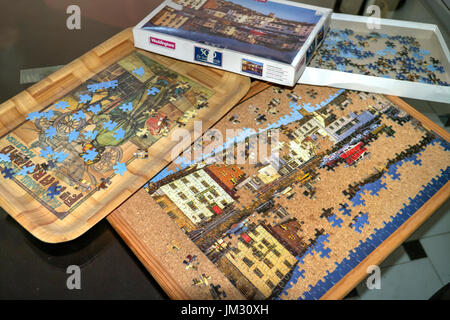 Teilweise abgeschlossen Puzzle mit einigen Stücken, die Verlegung in ein Fach warten auf Auswahl. Stockfoto