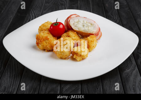 Feta-Käse mit Speck umwickelt und in Öl gebraten mit Kartoffel in Panade Stockfoto