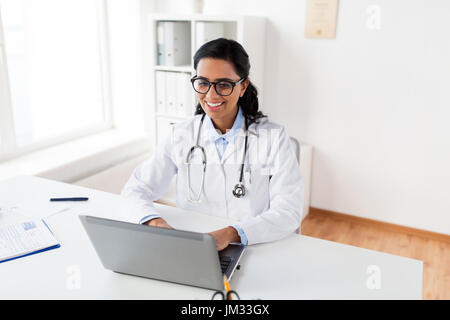 zufrieden Ärztin Tippen auf Laptop im Krankenhaus Stockfoto
