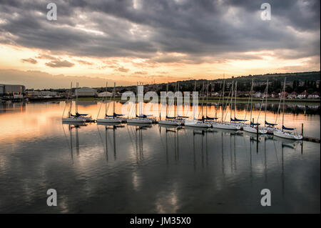 Yachten ankern in der Abenddämmerung mit stimmungsvoller Himmel auf einem Ponton in Portsmouth Harbour Stockfoto