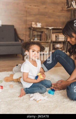 niedliche kleine Kind Mädchen spielen Spielzeug mit Mutter zu Hause Stockfoto