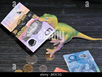 Selektiver Fokus auf australische Dollar fünf Hinweis in der Dinosaurier Mund mit Unscharf australischen Münzen und zehn Dollar Schein auf dem Tisch Stockfoto