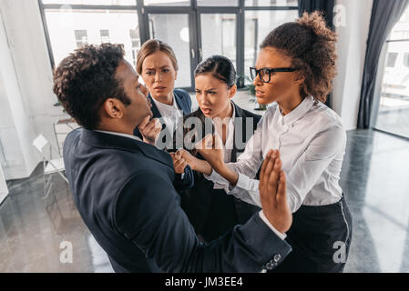 junge emotionale Geschäftsleute in festlich gekleidet Streit im modernen Büro, Business team meeting Stockfoto
