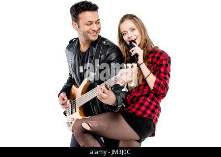 Glückliches junges Paar Musiker mit Mikrofon und e-Gitarre Musik zusammen isoliert auf weiss Stockfoto