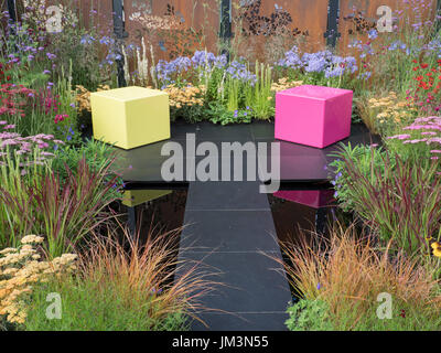 Das Farbe-BOX Schaugarten Designed von Charlie Bloom und Simon Webster - Silber-Schuld-Preisträger.  Blick auf den ganzen Garten mit zwei farbigen seati Stockfoto