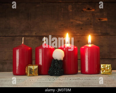 Vier rote Kerzen Advent auf einem rustikalen hölzernen Hintergrund, zwei Kerzen brennen, Scond Advent, Weihnachten Konzept Hintergrund Stockfoto