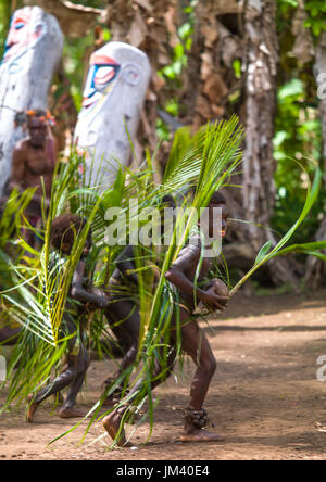 Nambas Kleinkinder bedeckt mit Palmenblättern tanzen vor Schlitz Gong Trommeln während des Palm-Baum-Tanzes, Malekula Insel, Gortiengser, Vanuatu Stockfoto