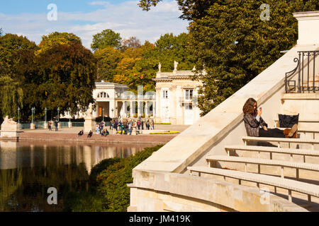 Warschau, Polen - Oktober 2, 2014: Junge Mädchen auf eine Bank der Amphitheater in krolewskie Lazienki Park (königlichen Bäder Park), das Wasser Palace Stockfoto