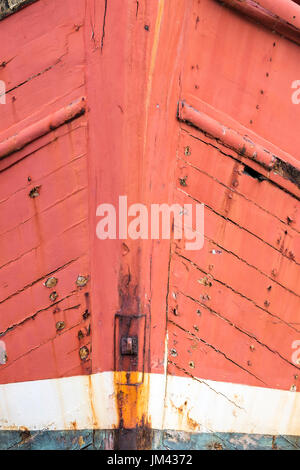 In der Nähe von Bogen von alten verlassenen Schiff auf dem Trockenen angedockt. Rote und blaue Farbe, plimsoll Line und Rost Bügeleisen arbeiten. Stark strukturierte und gut überstanden. Stockfoto