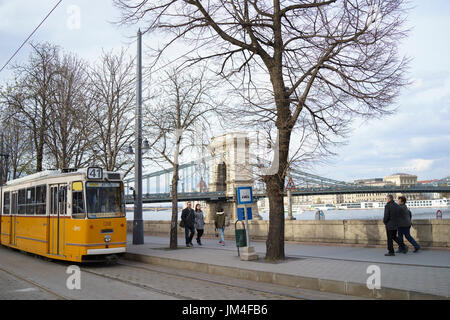 Fußgänger Fuß entlang der Donau mit einem Triebwagen und Kettenbrücke in Budapest, Ungarn, im Hintergrund 4. April 2015. Stockfoto