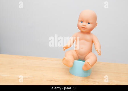 Puppe sitzt auf Töpfchen, Illistrate Töpfchen-training Stockfoto