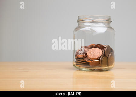 Glas mit britischen ein- und zwei-Cent-Münzen Stockfoto