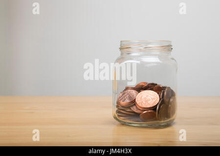 Glas mit niedrigen Wert britischen Münzen innerhalb Stockfoto
