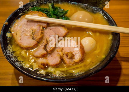 HAKONE, JAPAN - 2. Juli 2017: Delicious japanische Ramen-Nudeln mit Stäbchen über die Suppe in einem hölzernen Hintergrund Stockfoto