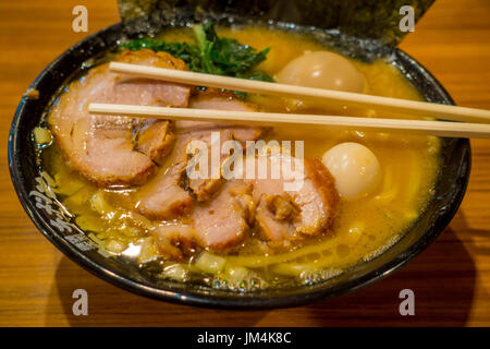 HAKONE, JAPAN - 2. Juli 2017: Delicious japanische Ramen-Nudeln mit Stäbchen über die Suppe in einem hölzernen Hintergrund Stockfoto