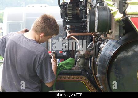 Mann, die Wartungsarbeiten auf Zugmaschine in Masham Steam Fair, Masham, North Yorkshire, UK Stockfoto