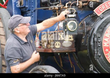 Mann, die Wartungsarbeiten auf Zugmaschine in Masham Steam Fair, Masham, North Yorkshire, UK Stockfoto