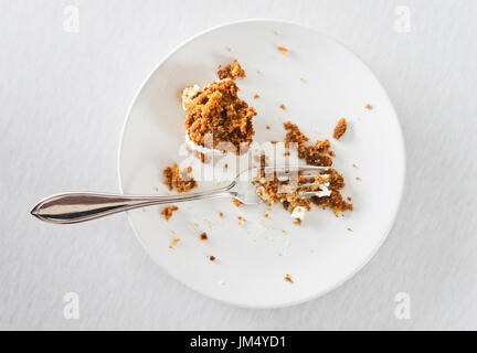 Halb gegessenen Kuchen auf weißen Teller mit Gabel. Stockfoto