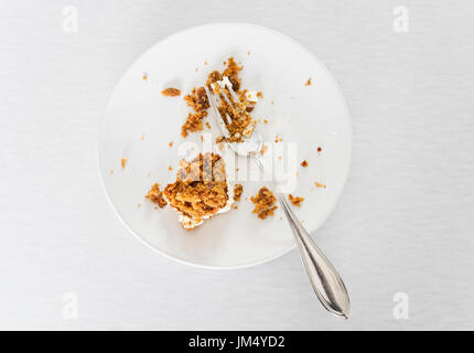 Halb gegessenen Kuchen auf weißen Teller mit Gabel. Stockfoto