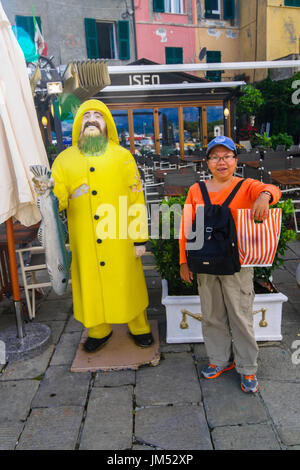 Touristischen posiert neben einem Fishermans-Statue in Porto Venere Italien Stockfoto